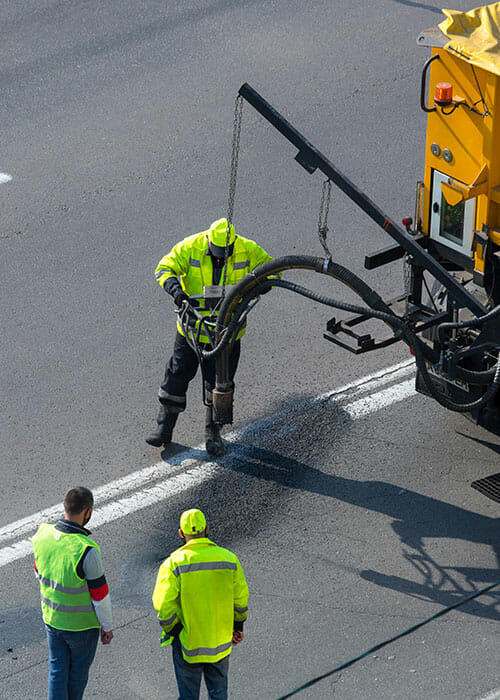asphalt technicians filling asphalt cracks on Utah roadways