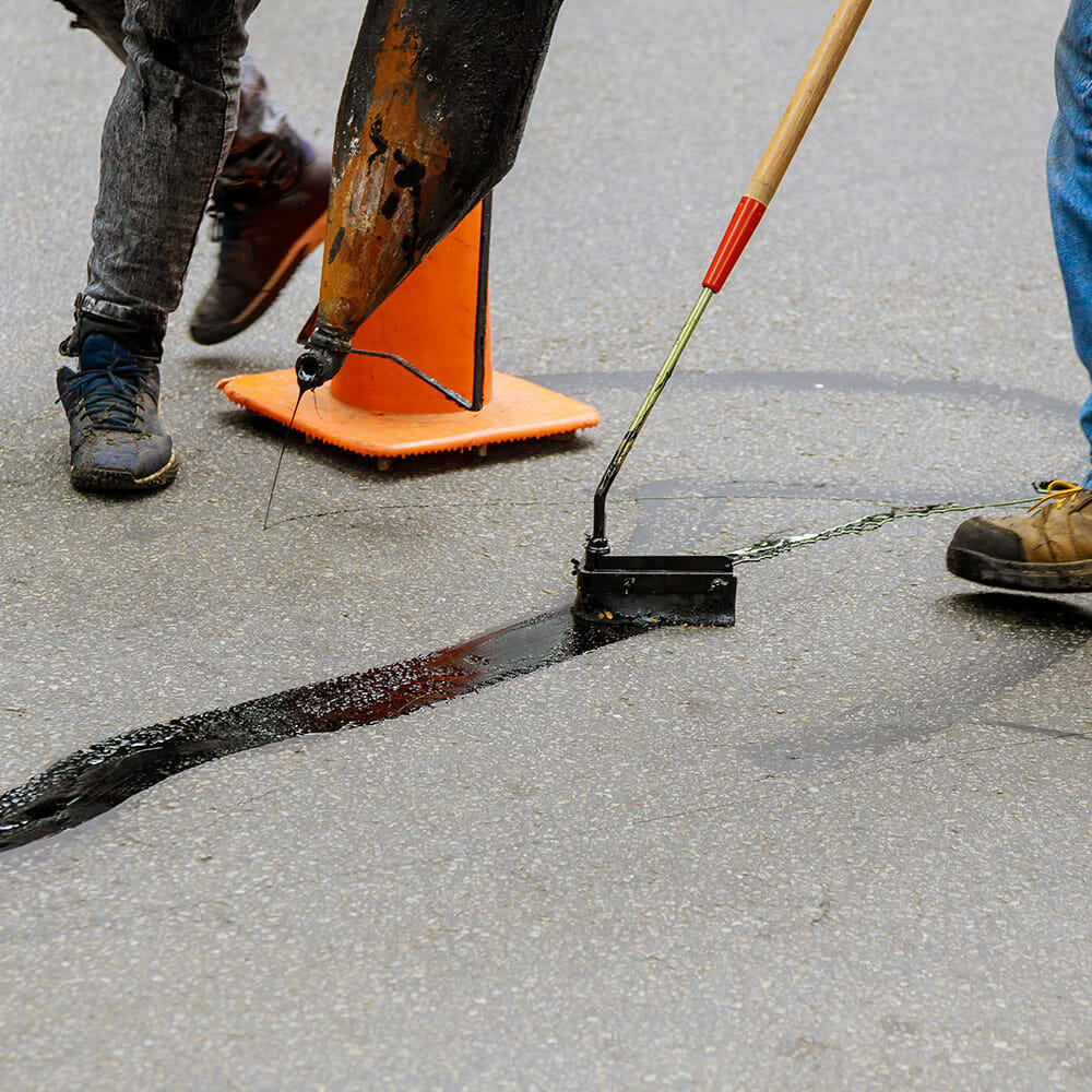 asphalt repair technicians filling in cracks in asphalt
